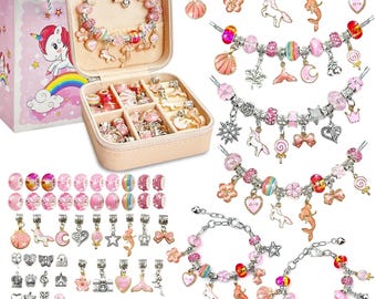 May include: A pink jewelry box with a unicorn design on a gift bag. The box contains a charm bracelet, charms, and beads in various shades of pink, silver, and rainbow colors. The charms include unicorns, shells, and stars.