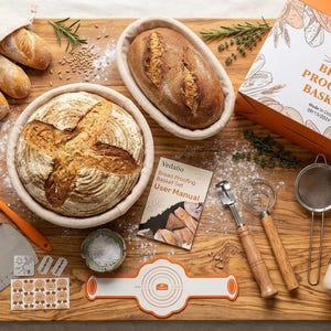 May include: A bread proofing basket set including two rattan baskets with loaves, a storage bag, a user manual, a metal dough scraper with a wooden handle, a silicone spatula, a scoring tool, a whisk, a sieve, and a glass jar with a cloth cover.