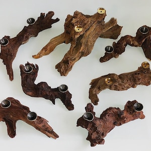 May include: A collection of handcrafted wooden pipes with metal bowls. The pipes are made from natural wood, showcasing various shapes and textures. The metal bowls are in shades of gold and silver, adding a contrasting element to the rustic aesthetic.