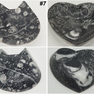 May include: Four decorative stone dishes. Two are cat-shaped, and two are heart-shaped. The dishes are black and white, with a marbled pattern. The cat-shaped dishes have pointed ears. The heart-shaped dishes have a smooth, curved shape. Each dish is labeled with a number.