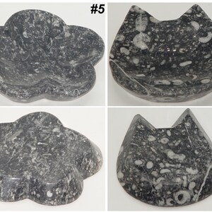 May include: Four decorative stone dishes. Two are flower-shaped, and two are cat-shaped. The dishes are dark gray with white and light gray marbling. The dishes are numbered #5 and #6.