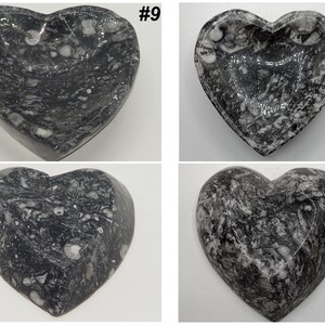 May include: Four heart-shaped decorative bowls. The bowls are made of a dark gray stone with white veining. The bowls are numbered #9 and #10. The bowls are likely used for holding small items.