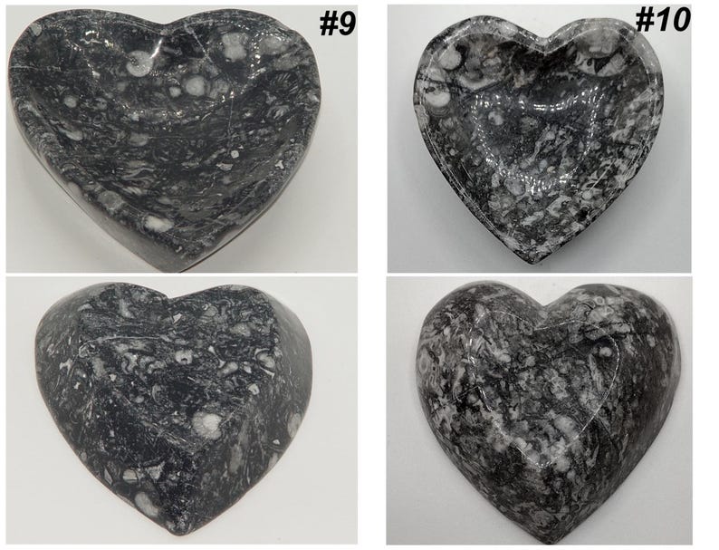 May include: Four heart-shaped decorative bowls. The bowls are made of a dark gray stone with white veining. The bowls are numbered #9 and #10. The bowls are likely used for holding small items.