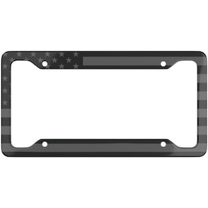 May include: A black license plate frame with a gray American flag design. The frame features the stars and stripes of the flag, with a thin gray line. The frame has four mounting holes.