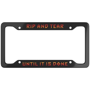 May include: Black license plate frame with the text "RIP AND TEAR" above and "UNTIL IT IS DONE" below in orange and red gradient lettering. The frame has four mounting holes.