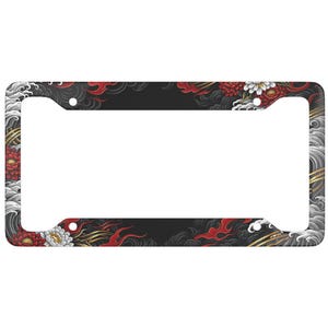 May include: Black license plate frame with a Japanese-inspired design. The frame features red, white, and gold floral and wave patterns against a black background. The design includes red flames and white flowers.