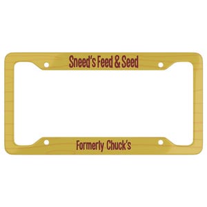 May include: A license plate frame with a wood grain design. The text "Sneed's Feed & Seed" is printed at the top, and "Formerly Chuck's" is printed at the bottom in a dark red color.