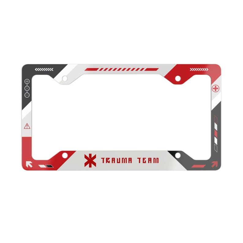 May include: A rectangular license plate frame featuring a white, red, and dark gray geometric design. The frame includes the text "TRAUMA TEAM" in red lettering, a red medical star symbol, various directional arrows, and warning icons.