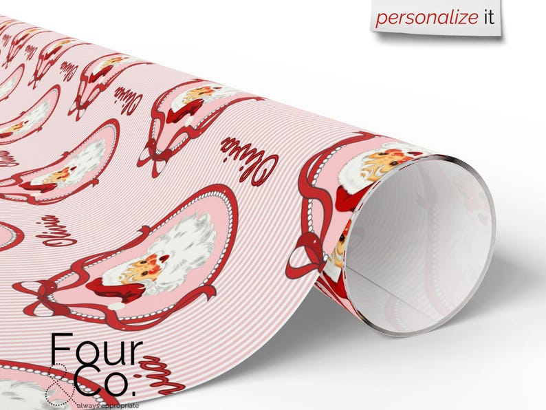 May include: A roll of pink wrapping paper featuring a repeating pattern of Santa Claus illustrations within oval frames, accented with red ribbons and the name "Olivia". The paper has a striped background and the text "Four Co." at the bottom.