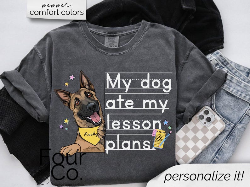 May include: A dark gray t-shirt with a white graphic of a German Shepherd dog with the text "My dog ate my lesson plans".