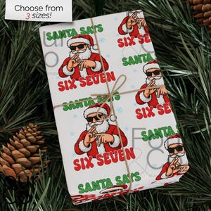 Pode incluir: Papel de embrulho branco com um padrão repetido do Pai Natal a usar óculos de sol e o texto "SANTA SAYS SIX SEVEN". O presente embrulhado é amarrado com barbante e rodeado por pinhas e pinheiro.