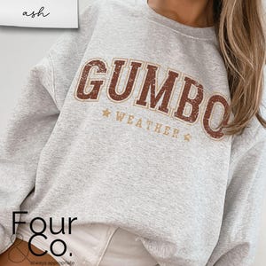 May include: A gray sweatshirt with a brown and white graphic that says "GUMBO WEATHER".
