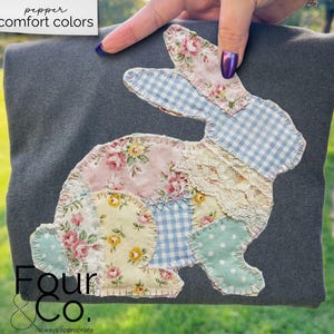 May include: A dark gray fabric square with a patchwork bunny applique. The bunny is made of floral, gingham, and lace fabrics in pastel colors. The text "pepper comfort colors" is at the top, and "Four & Co." is at the bottom.