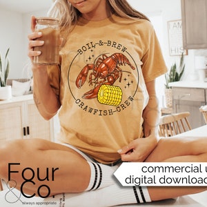 May include: A yellow t-shirt with a graphic of a red crawfish holding a yellow ear of corn. The text "BOIL & BREW CRAWFISH CREW" is printed on the shirt.