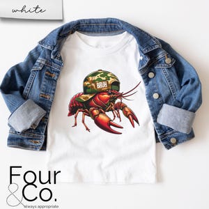 May include: White t-shirt with a cartoon crayfish wearing a camouflage hat that says "Bruh".