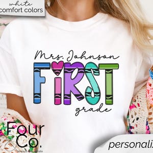 May include: White t-shirt with the text "Mrs. Johnson FIRST grade" in rainbow crayon colors. The text is surrounded by a heart.
