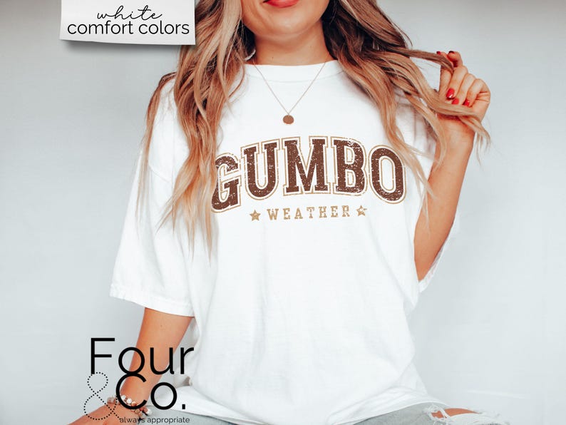 May include: White t-shirt with a brown and gold graphic that says "GUMBO WEATHER" with stars on either side of the text.