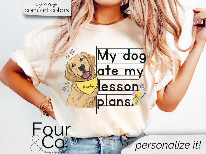 May include: A white t-shirt with the text "My dog ate my lesson plans." printed on it. A cartoon image of a golden retriever dog wearing a yellow bandana with the name "Rocky" is next to the text. The shirt is being worn by a person with long blonde hair.