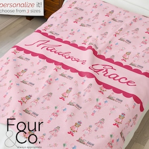 Puede incluir: Manta rosa personalizada con un patrón repetido de osos bailarines y los nombres "Madison Grace". La manta tiene un borde festoneado y el texto "personalize it! choose from 3 sizes".