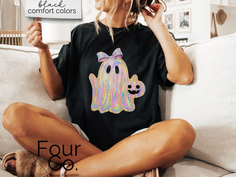 May include: Black t-shirt with a holographic ghost and a pumpkin graphic. The text "Four Co." is on the bottom of the shirt.
