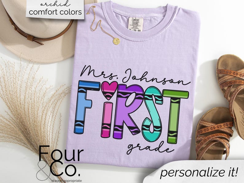 May include: Purple t-shirt with the text "Mrs. Johnson FIRST grade" in colorful crayon-like letters. The text is surrounded by a white border.