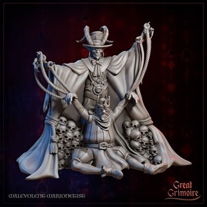 May include: A gray 3D printed miniature of a skeletal figure with horns and a top hat, holding a rope attached to a kneeling figure wearing a crown and armor. The figures are surrounded by skulls. The text "Malevolent Marionettist" and "Great Grimoire" are visible at the bottom of the image.