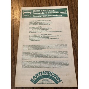 May include: A vintage canning equipment instruction sheet. The sheet is white with black and green text, including the brand name "MIRRO" and "EARTHGROWN". It provides instructions for water bath canning, including jar sizes and safety guidelines.
