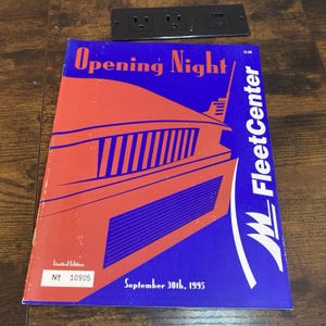 May include: A rectangular program booklet titled Opening Night FleetCenter dated September 30th, 1995. The cover features a stylized orange building graphic on a blue background with the text Limited Edition and the number 10905 in a white box.