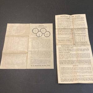 May include: Two vintage paper instruction manuals for Weaver scopes. The left sheet details reticles with diagrams and text. The right sheet provides adjustment instructions and tables. Both documents are off-white with black printed text.