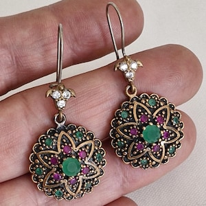 Boucles d'oreilles artisanales turques à motif ottoman antique, en argent et bronze, avec pierres précieuses rubis et émeraude brutes.