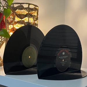 May include: Two black vinyl records used as bookends. The record on the right has a Reader's Digest label with the text "Harry James & His Orchestra" and "The Listening and Dancing" printed on it.