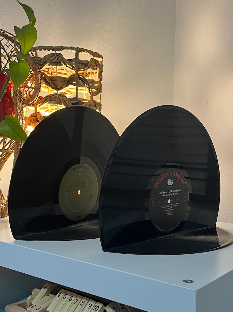 May include: Two black vinyl records used as bookends. The record on the right has a Reader's Digest label with the text "Harry James & His Orchestra" and "The Listening and Dancing" printed on it.
