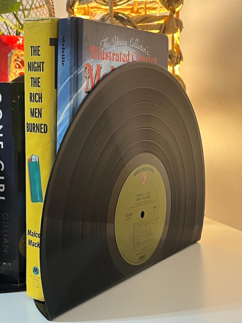 May include: A pair of bookends made from a black vinyl record. The record is a half-circle and has a label that reads "Warner Bros. Records" and "The Monkees" with the album title "Headquarters" and the song title "Daydream Believer".