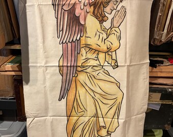 May include: A hand-painted canvas depicting an angel with pink and brown wings, wearing a yellow robe and a gold crown, with hands clasped in prayer.