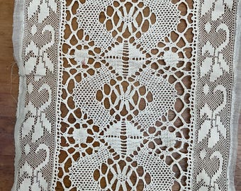 May include: White lace trim with a delicate floral pattern. The trim has a repeating design of small flowers and leaves.