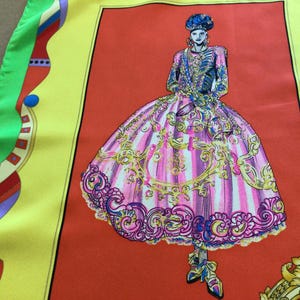 Puede incluir: Pa&ntilde;uelo de seda con una ilustraci&oacute;n de moda de una persona con vestuario hist&oacute;rico. El dise&ntilde;o incluye un vestido a rayas rosas y blancas con adornos dorados, sobre un fondo rojo, enmarcado por bordes amarillos y verdes.