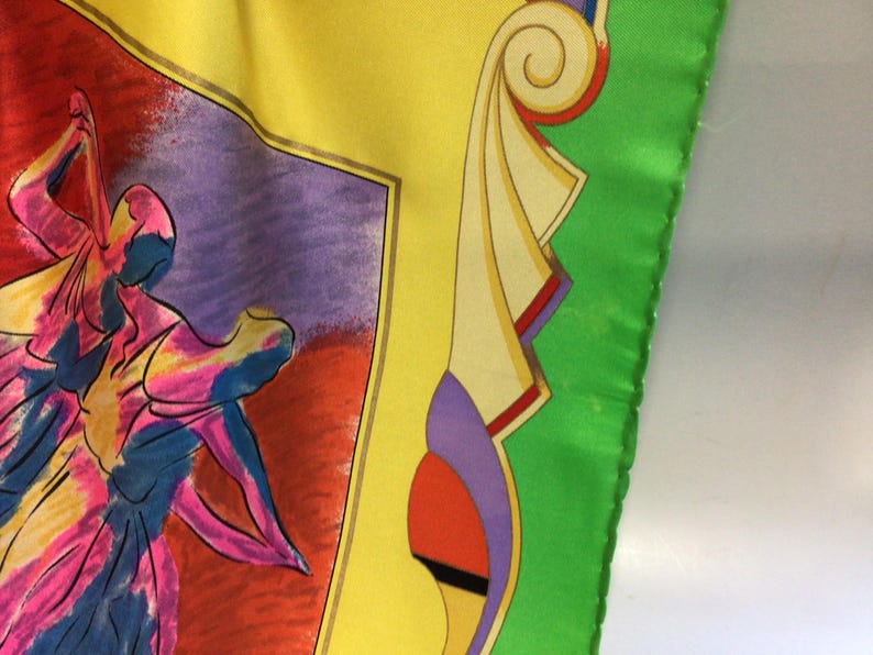 Puede incluir: Un pa&ntilde;uelo de seda colorido con un dise&ntilde;o abstracto. El pa&ntilde;uelo presenta un bailar&iacute;n en tonos de rosa, azul y amarillo sobre un fondo rojo y morado. El borde es amarillo, con bordes verdes.