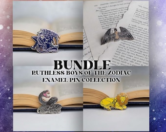 Puede incluir: Un conjunto de cuatro pines de esmalte que representan los signos del zodíaco: un dragón negro, un águila plateada, una serpiente negra y un león dorado. Los pines se muestran en libros abiertos con el texto "BUNDLE RUTHLESS BOYS OF THE ZODIAC ENAMEL PIN COLLECTION".