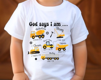 May include: A white t-shirt with the text "God says I am..." and various construction vehicle illustrations in yellow and black. The shirt also includes the words "Victorious", "Strong", "Chosen", "Capable", and "Worthy".
