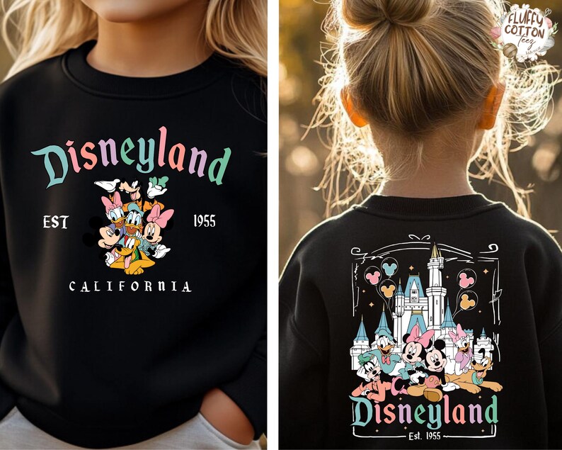 May include: Black sweatshirt with "Disneyland" in a colorful script, featuring Mickey Mouse, Donald Duck, and other Disney characters. The sweatshirt also has "EST 1955" and "CALIFORNIA" printed on it.