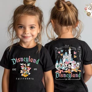 May include: Black t-shirts with Disneyland graphics. The front of the shirt features the Disneyland logo with Mickey Mouse and friends. The back of the shirt has a castle graphic with Disney characters. Est. 1955.
