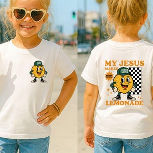 K&ouml;nnte beinhalten: Wei&szlig;es T-Shirt mit einer Cartoon-Zitrone, die eine gr&uuml;ne Kappe und Turnschuhe tr&auml;gt. Auf der Vorderseite des T-Shirts ist die Zitrone abgebildet. Auf der R&uuml;ckseite des T-Shirts steht der Text "MY JESUS MAKES LEMONADE".