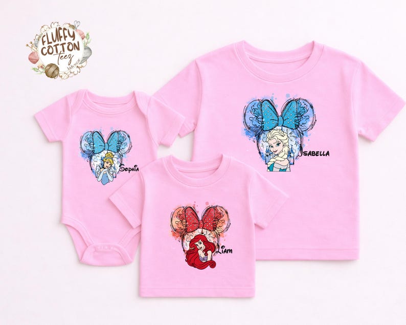 以下が含まれることがあります： ピンク色のベビーボディスーツとTシャツ。ディズニーのプリンセスデザインが特徴です。シンデレラ、エルサ、アリエルが描かれ、それぞれリボンと名前が付いています。家族やグループに最適です。