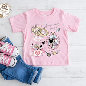 Puede incluir: Camiseta rosa de manga corta con un dise&ntilde;o de Minnie y Daisy Duck. El dise&ntilde;o incluye corazones, una taza de t&eacute; y el texto "Girls just wanna have fun". Zapatillas rosas y vaqueros azules tambi&eacute;n en la imagen.
