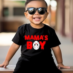 May include: A black t-shirt with a red graphic that says "Mama's Boy" with a hockey mask in the middle of the word "Boy".