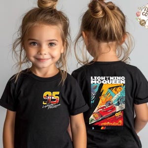 May include: Black Lightning McQueen t-shirts for children. The front displays the number 95 and the Lightning McQueen logo. The back of the shirt has a colourful graphic of Lightning McQueen racing.
