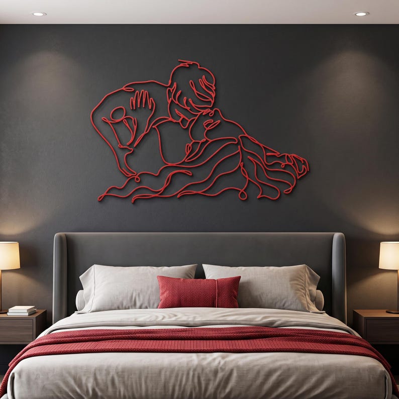 Large metal bedroom wall art showcasing a romantic couple kiss in vibrant red line art, displayed elegantly above a modern bed with matching linens.