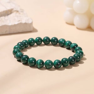 Peut inclure: Un bracelet en perles de malachite verte. Les perles sont rondes et ont une finition naturelle et polie.