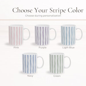 May include: White ceramic mugs with vertical stripe designs in pink, purple, light blue, navy, and green. The text "Choose Your Stripe Color" is at the top, with "Choose during personalization" below it. Each mug has a white handle.
