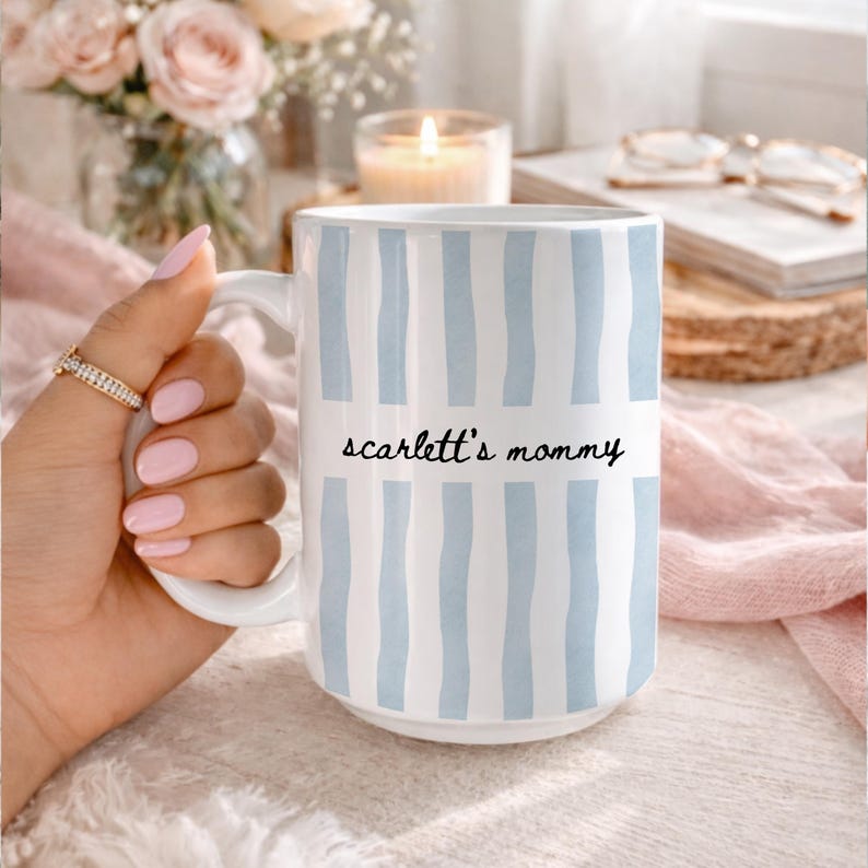 Striped ceramic mug with handwritten mama text style, personalized with a child name, designed as a modern motherhood coffee mug gift.